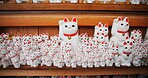 Japanese, traditional and neko maneki or good luck cat in shop for fortune, culture or heritage. Sculpture figure, gotokuji statue and travel destination in Tokyo for local history, spiritual or gift