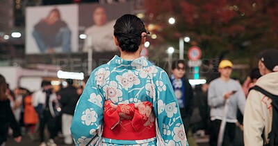 Buy stock photo Back, city and Japanese woman on street at night with crowd for culture, heritage or tradition. Travel, fashion kimono and person walking on road of urban Tokyo town for vacation or sightseeing