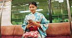 Woman, japan and train with kimono, phone and travel with public transport, metro bullet in city. Person, journey or traditional clothes in motion blur on weekend or commute in tokyo on adventure