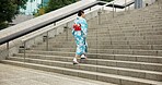 Woman, Japanese and walking in kimono for traditional on stairs in Tokyo for wellness, health or peace. Female person, outdoor and urban city explore for downtown commute for local, steps or culture