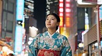 Thinking, night and Japanese woman with decision, travel and traditional clothes with wonder, relax and calm. Person, outdoor or girl in the streets, peace, commute or thoughts with culture or lights