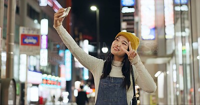 Buy stock photo Peace, hands and selfie by Japanese woman in a city for travel, adventure or journey outdoor. V sign, emoji or happy lady influencer in Japan for content creation, blog or social media live streaming