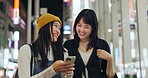 Woman, friends and Japanese or cellphone in city street for night communication, research or location. Female person, Tokyo road and lights internet network for social media news, adventure or travel