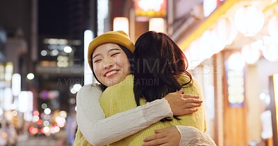 Buy stock photo Woman, friends and hug in Japanese city or happy reunion for party night, adventure or Tokyo. Female people, embrace and dark or bokeh on street with light or international travel, journey or evening