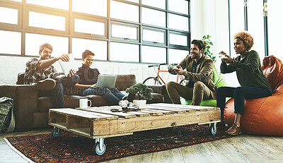 Buy stock photo Shot of a group of designers having fun while playing games