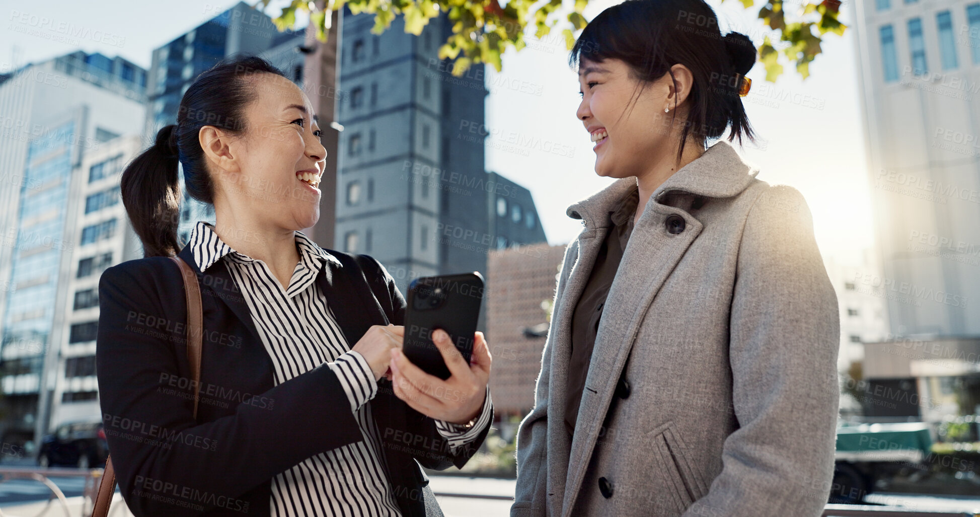 Buy stock photo Phone, laughing and Japanese business woman in city together for travel, journey or commute. Collaboration, planning and funny with employee friends reading text message for discussion in Tokyo