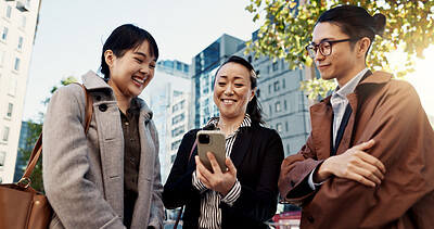 Phone, smile and Japanese business people in city for travel, communication or networking together. Collaboration, internet or email with happy employee group outdoor for commute in Tokyo town