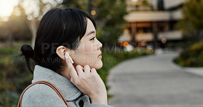 Japanese woman, earphones and walk in city with listening, music and streaming subscription on road. Girl, person and audio tech for podcast, radio and sound with travel on metro sidewalk in Tokyo