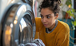 Woman, laundry and clean clothes loaded into a washing machine for laundromat, chores or self service. Black, young girl or teenager doing cleaning duties for hygiene, cleanliness and housework