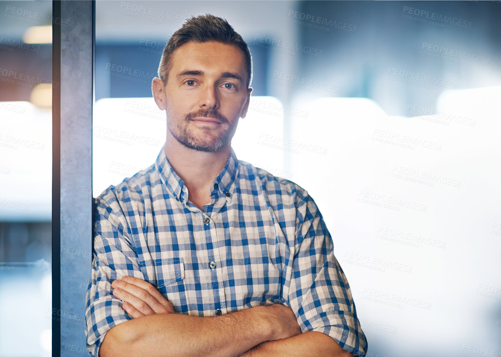 Buy stock photo Portrait of a businessman standing with his arms crossed in the office