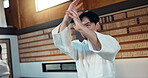 Man, martial arts and training aikido in dojo or self defence wellness, practice or combat sports. Male person, gee uniform and hands or Japanese exercise for battle challenge, fitness or fight power