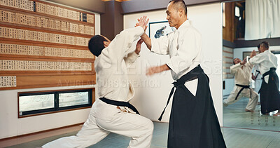 Buy stock photo Aikido, sensei and master in a fight of martial arts with student in self defence, discipline and training. Demonstration, class or Japanese man with black belt in fighting with education of skill