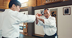 Aikido, sports and martial arts training class with students and sensei, self defense and discipline. Fitness, fight and education, black belt with Japanese people and workout for exercise in dojo.