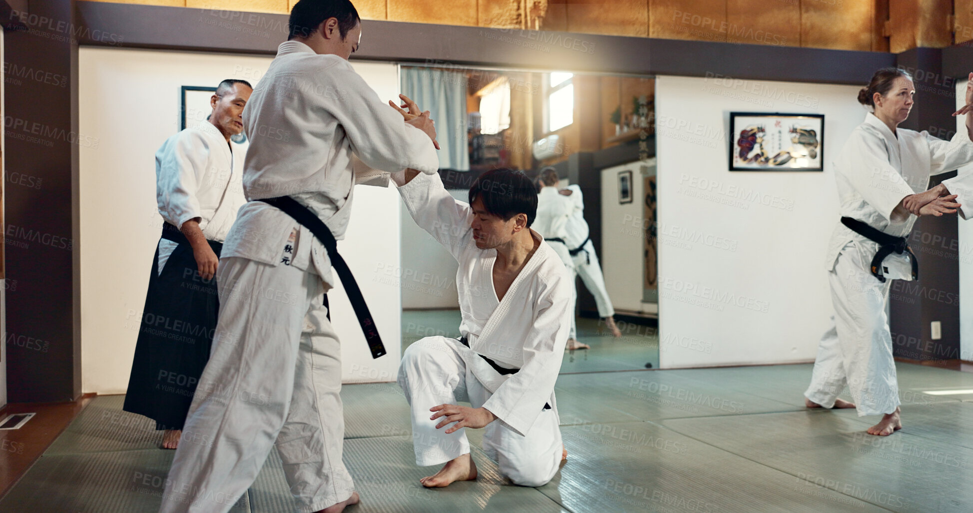 Buy stock photo Martial arts, sensei and Japanese students with training, fitness and action in class for defence or technique. Aikido, people or fighting with discipline, uniform or confidence for culture and skill