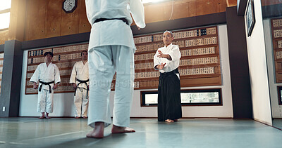 Aikido, sensei and Japanese students with fitness, training and action in class for defence or technique. Martial arts, people or fighting with discipline, uniform or confidence for culture and skill