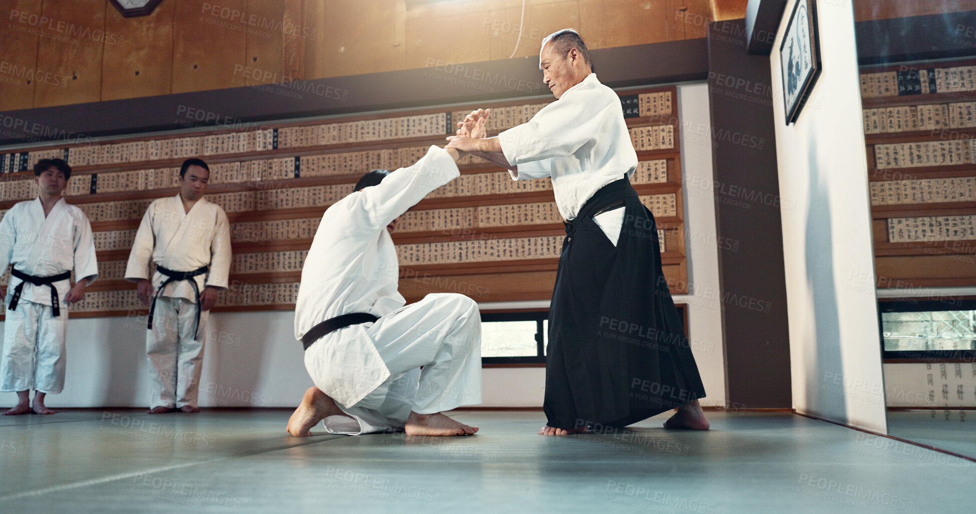 Buy stock photo Aikido, sensei and Japanese students with discipline, fitness and action in class for defence or technique. Martial arts, people or fighting with training, uniform or confidence for culture and skill