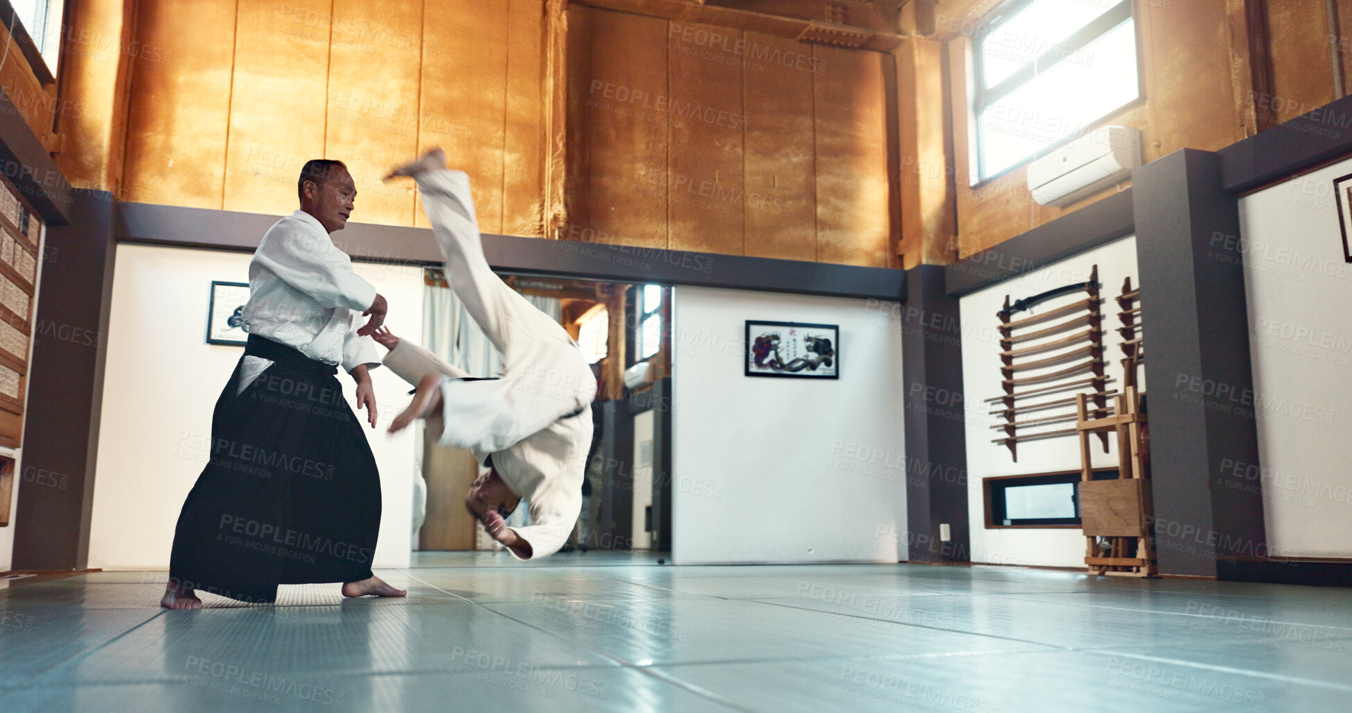 Buy stock photo Aikido, fight and sensei master in martial arts with training of student in self defence or discipline. Class, demonstration and Japanese man with black belt in fighting for education of skill