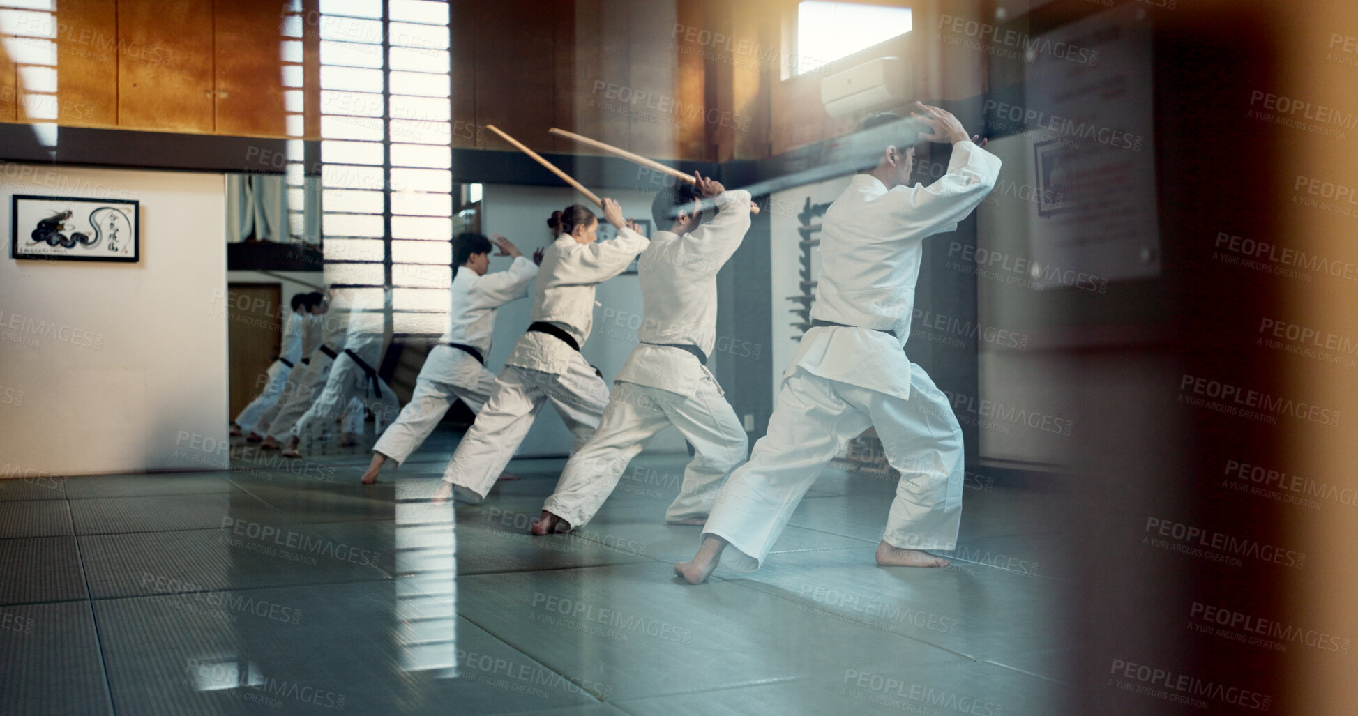 Buy stock photo Aikido, dojo class and people training for self defense, combat and Japanese group practice sword technique. Black belt students, transparent window and learning martial arts for safety protection