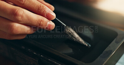 Hand, closeup of brush in ink for writing and calligraphy or ancient stationery for art and inkstone. Japanese creativity, black paint with paintbrush and person stroke with traditional vintage tools
