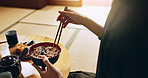 Closeup of bowl of noodles, hands and man is eating food, nutrition and sushi with chopsticks in Japan. Hungry for Japanese cuisine, soup and Asian culture with traditional meal for lunch or dinner