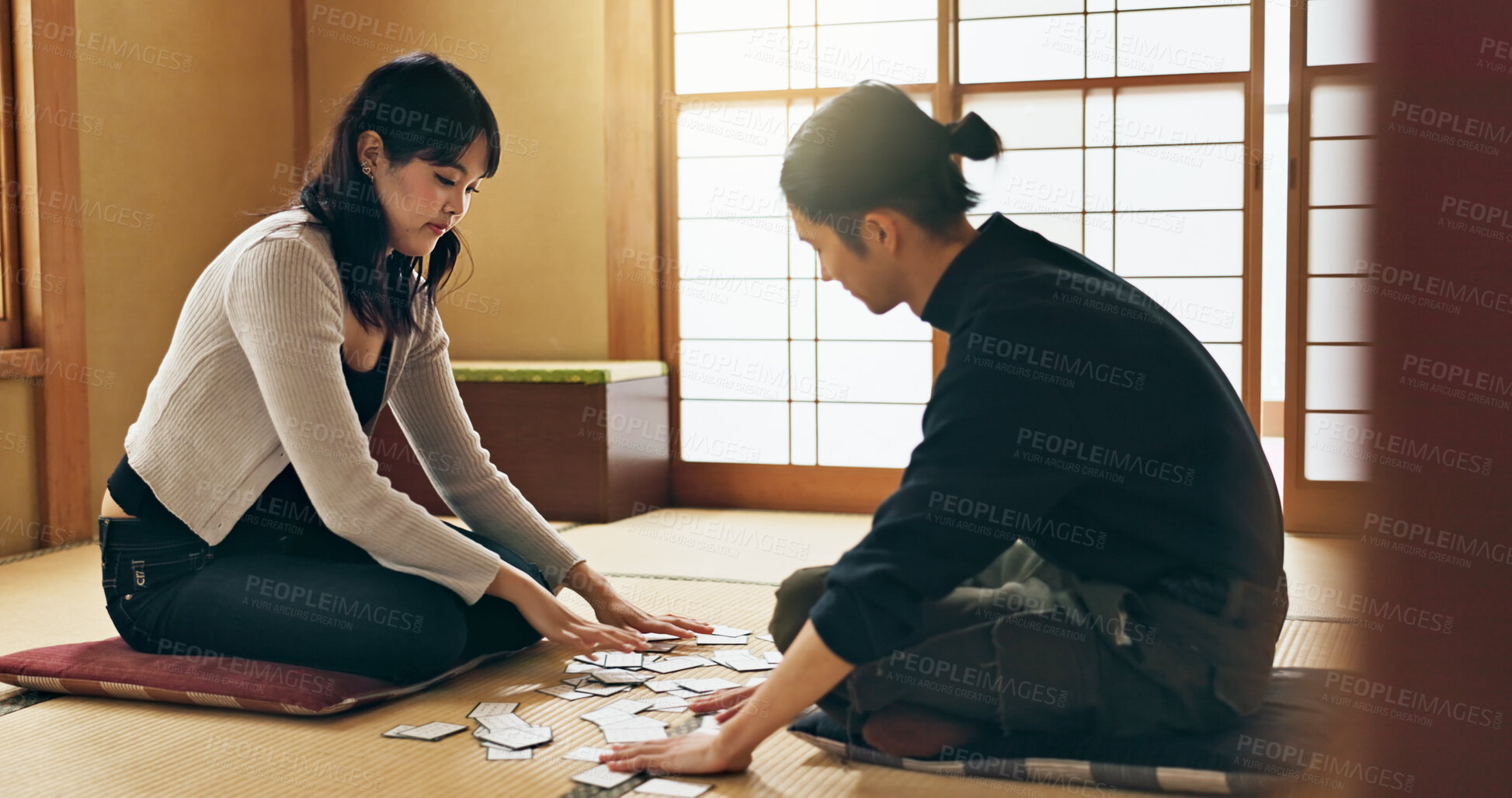 Buy stock photo Man, woman and game with Japanese cards on floor in challenge, contest or problem solving with clue. People, couple and karuta for competition with paper, reading or play together to relax in home