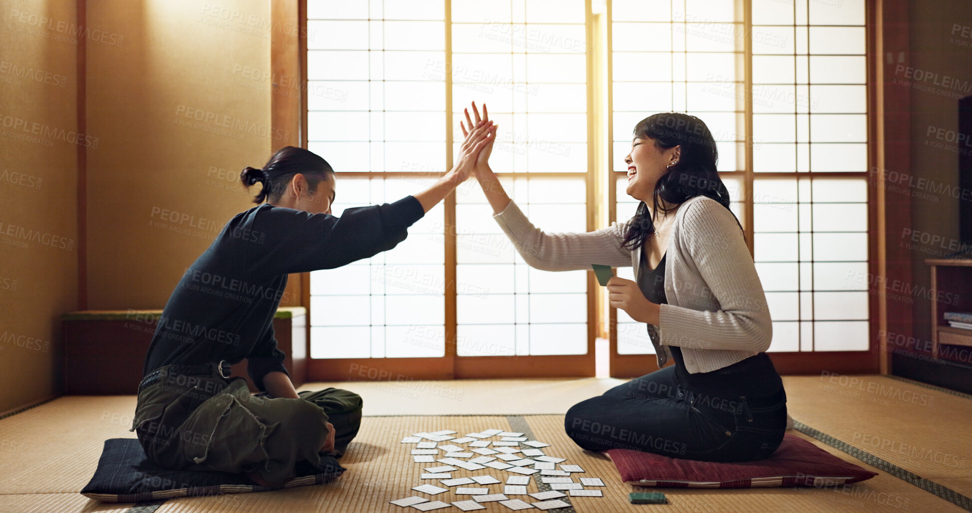 Buy stock photo Man, woman and game with cards, high five and challenge on floor, contest or problem solving with clue. People, couple and karuta for competition with paper, reading and celebration for win in home