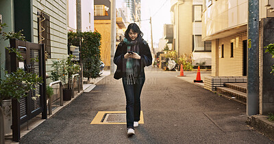 Japanese woman, phone and texting in city, street and typing for contact, email and notification on travel. Girl, person and smartphone for social media, app and mobile networking on road in Tokyo