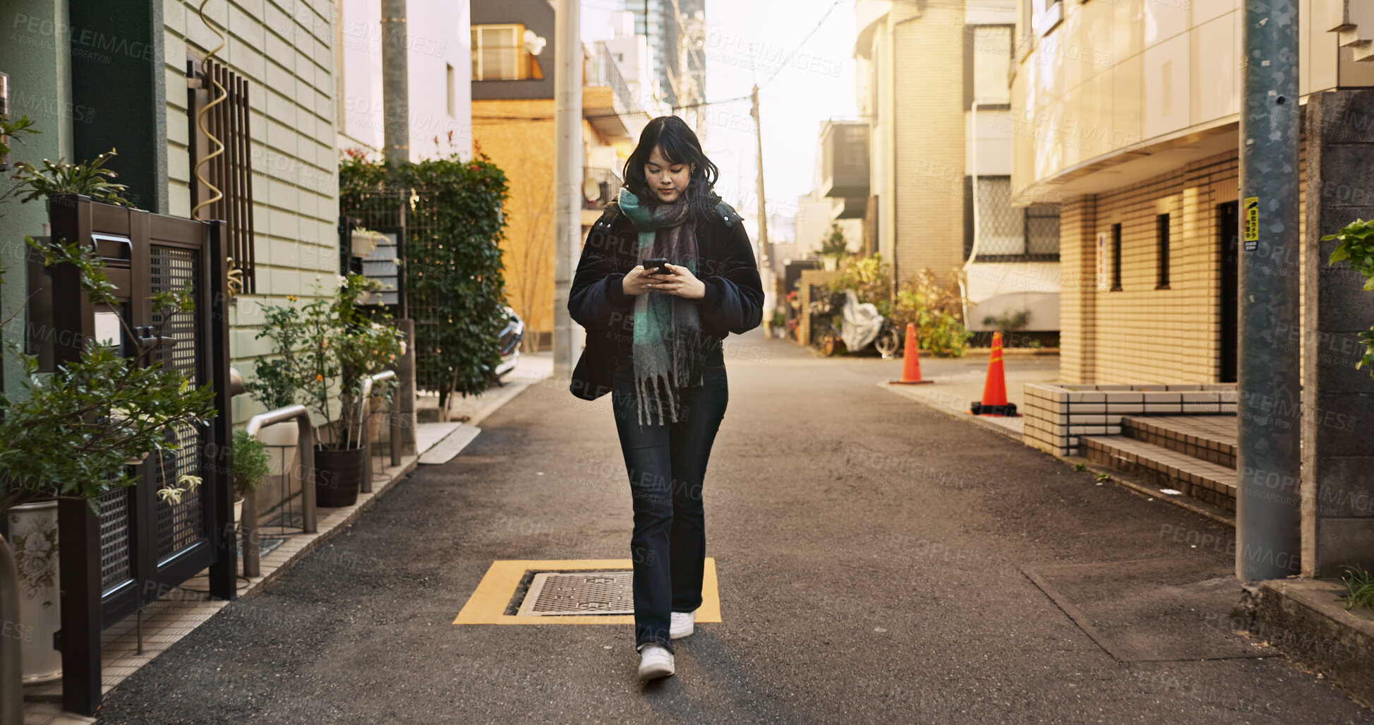 Buy stock photo Japanese woman, phone and texting in city, street and typing for contact, email and notification on travel. Girl, person and smartphone for social media, app and mobile networking on road in Tokyo