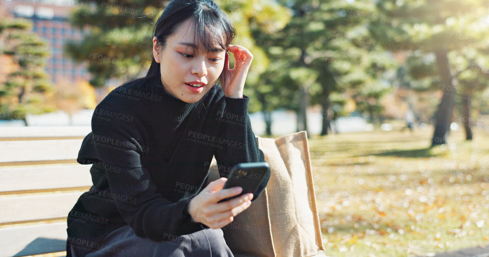 Buy stock photo Happy asian woman, phone and sitting on park bench for social media, communication or networking. Female person smile in relax on mobile smartphone for online search, streaming or reading in nature