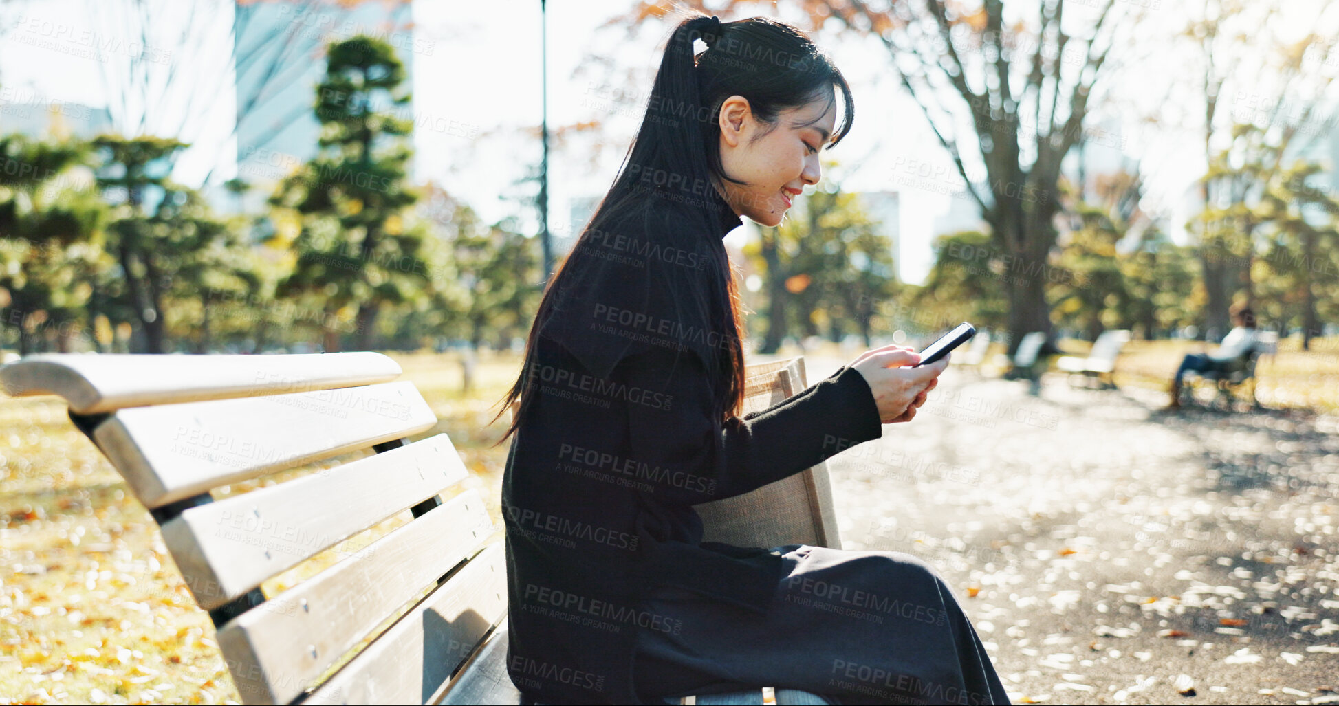 Buy stock photo Happy asian woman, phone and typing on park bench for social media, communication or networking. Female person smile in relax on mobile smartphone for online search, streaming or reading in nature