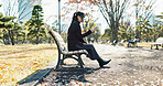 Asian woman, walking and relax on park bench with phone for social media, communication or networking. Female person sitting with mobile smartphone for online search, streaming or break in nature