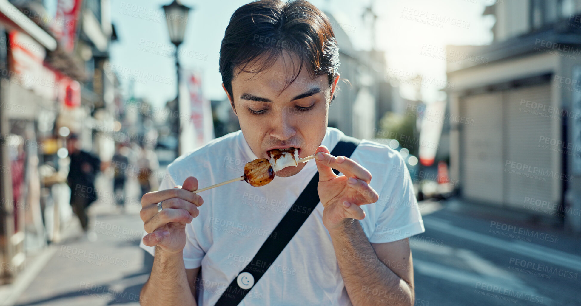 Buy stock photo Man, street food and eating kebab on walk on travel, city and hungry for goheimochi with nutrition, diet or lunch. Person, rice snack and skewer on metro sidewalk, vacation and urban road in Japan
