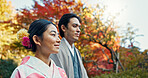 Asian couple, walking in garden and sunshine, peace and thinking about life, reflection and date in nature. Travel, people together in Japanese park for fresh air and calm with love, care and trust
