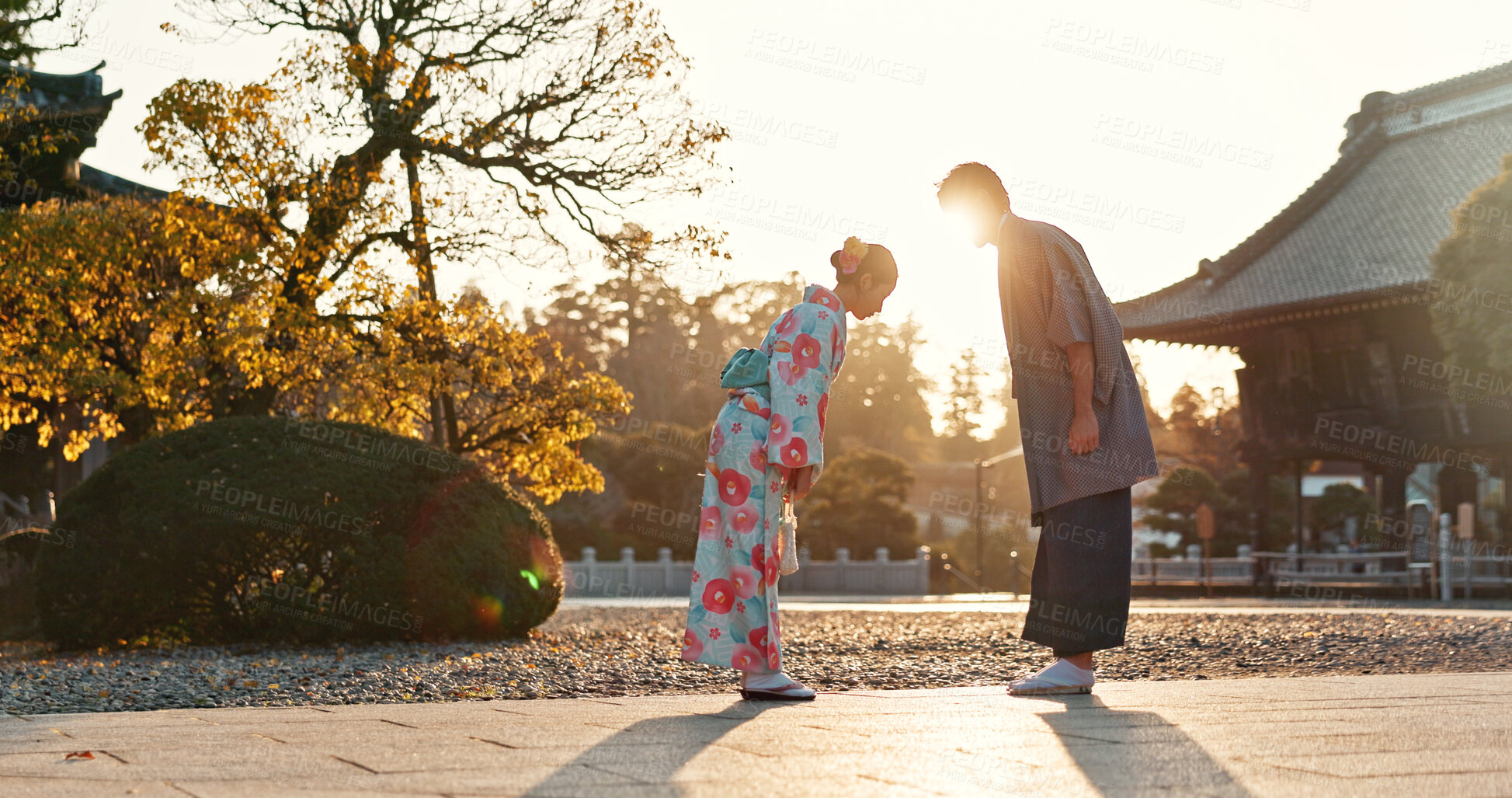 Buy stock photo Japanese people at temple, bow and traditional clothes with hello, nature and sunshine with respect and culture. Couple outdoor, greeting with modesty and tradition, polite and kind for religion