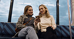 Happy woman, friends and phone on train for social media, communication or networking in public transport. Female person or people talking with mobile smartphone for online search on railway ride
