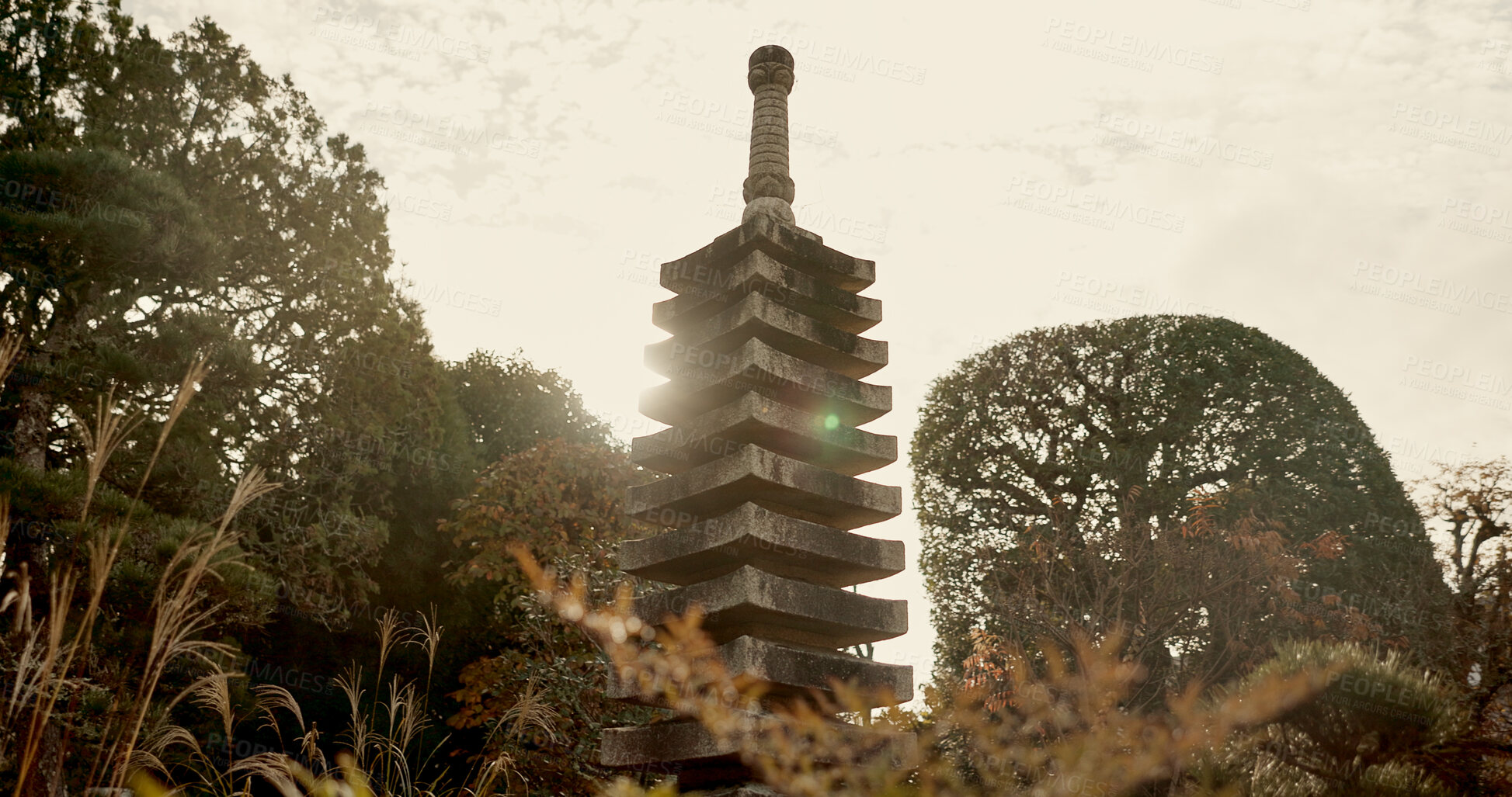 Buy stock photo Japanese temple, culture and sculpture in garden for zen, mindfulness or peace with trees in nature. Spiritual, Asian architecture and concrete structure with plants in forest or woods in morning