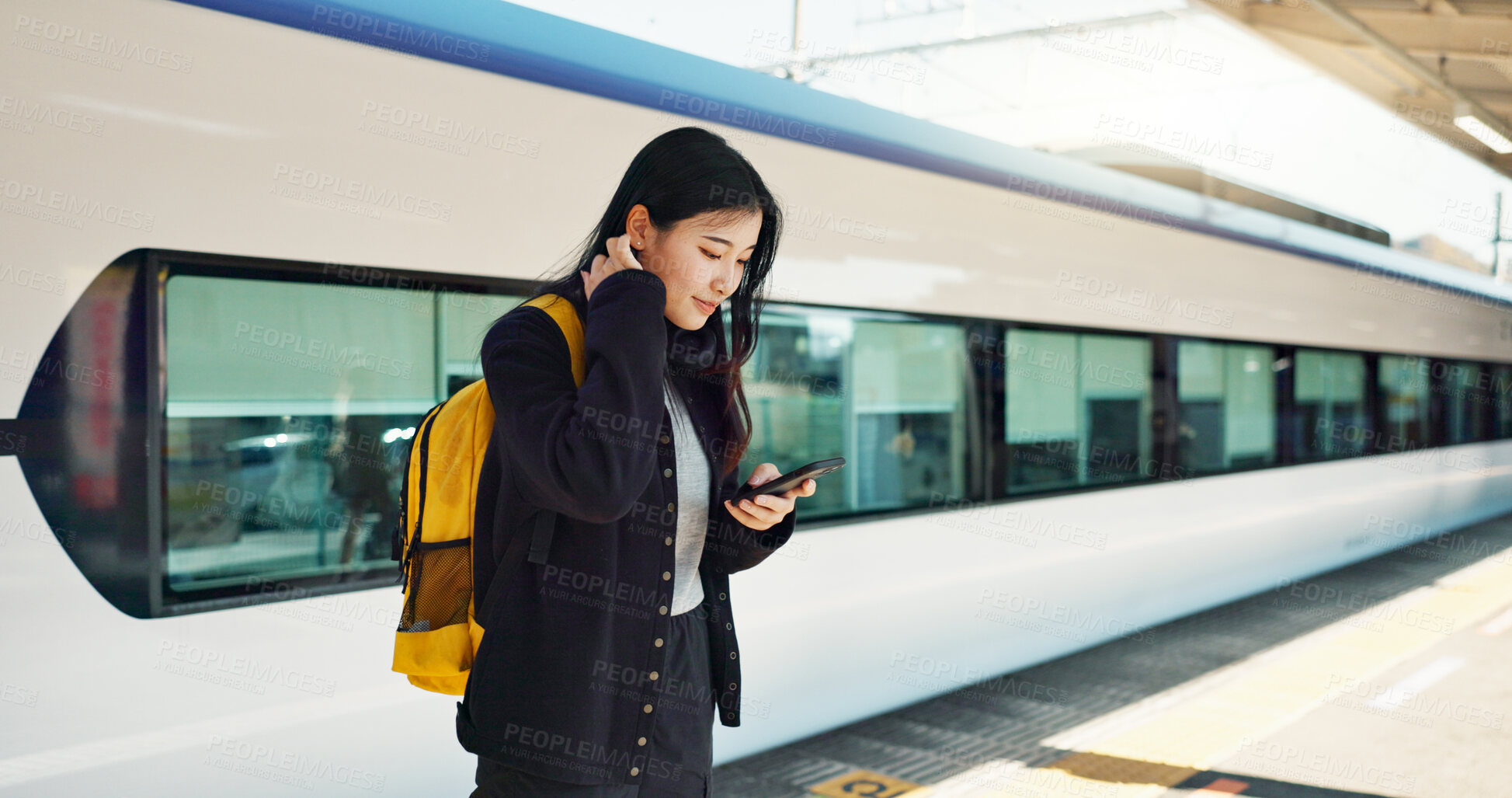 Buy stock photo Asian woman, phone and train for social media, travel or communication at railway station. Female person smile with backpack or bag on mobile smartphone waiting for transportation, trip or traveling