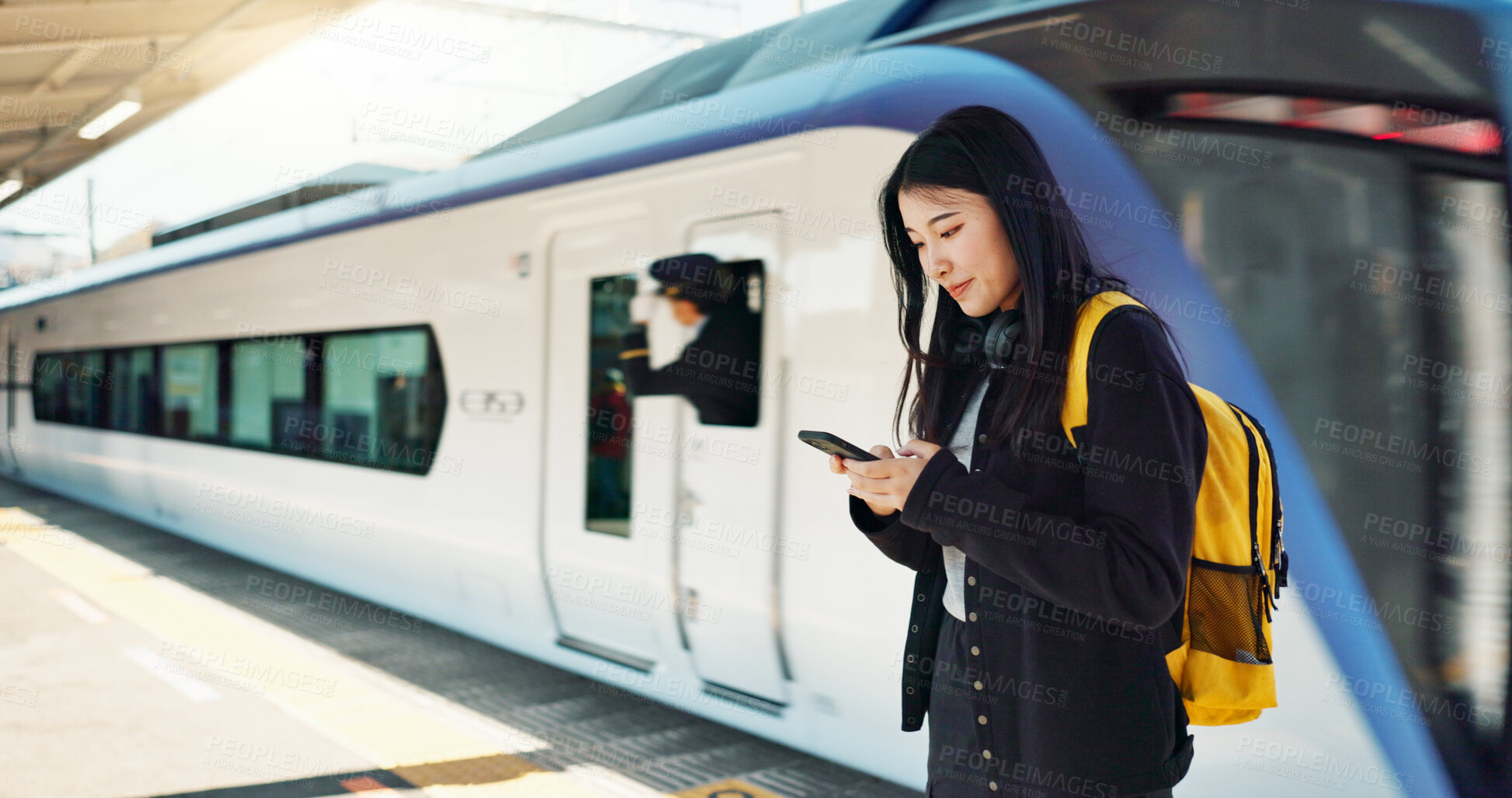 Buy stock photo Asian woman, phone and train for travel, communication or social media at railway station. Female person smile with backpack or bag on mobile smartphone waiting for transportation, trip or traveling