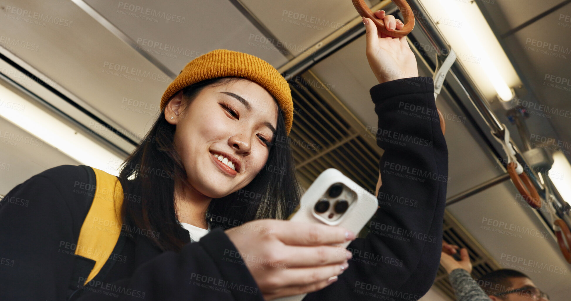 Buy stock photo Japanese woman, phone and texting in train, smile and travel with click, press and check schedule on app. Girl, person and smartphone with chat, reading blog and social network with public transport