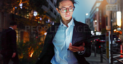 Tablet, night and Asian businessman in the city reading a blog on a website or internet. Online, glasses and young professional male person networking on digital technology in urban town street.