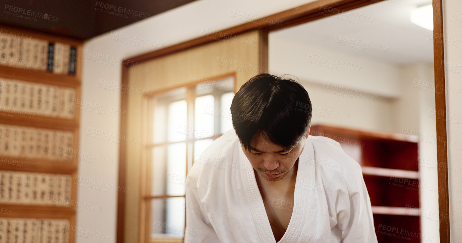 Buy stock photo Aikido student, bow or man in dojo to start practice, discipline or self defense education in Japan. Black belt master greeting, athlete learning respect or ready in fighting class or aikido training