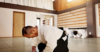 Buy stock photo Aikido class, sensei and students with bow, martial arts or respect for calm at training, gym or dojo. Japanese people, floor and club for exercise, workout and fitness with fight, ready and battle