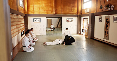 Students, aikido or teaching Japanese martial arts in dojo for practice, body movement or self defense. Combat demonstration, group of people or training workout for fighting, education or class