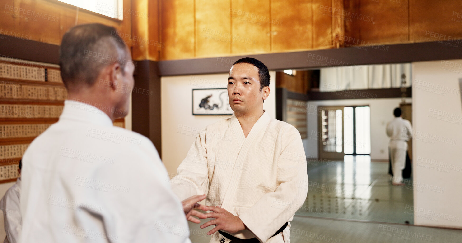 Buy stock photo Aikido dojo, men and sensei for martial arts, learning or advice for combat at training, gym and class. Japanese people, moving hands or sport for fight, workout or fitness with zen, conflict or club