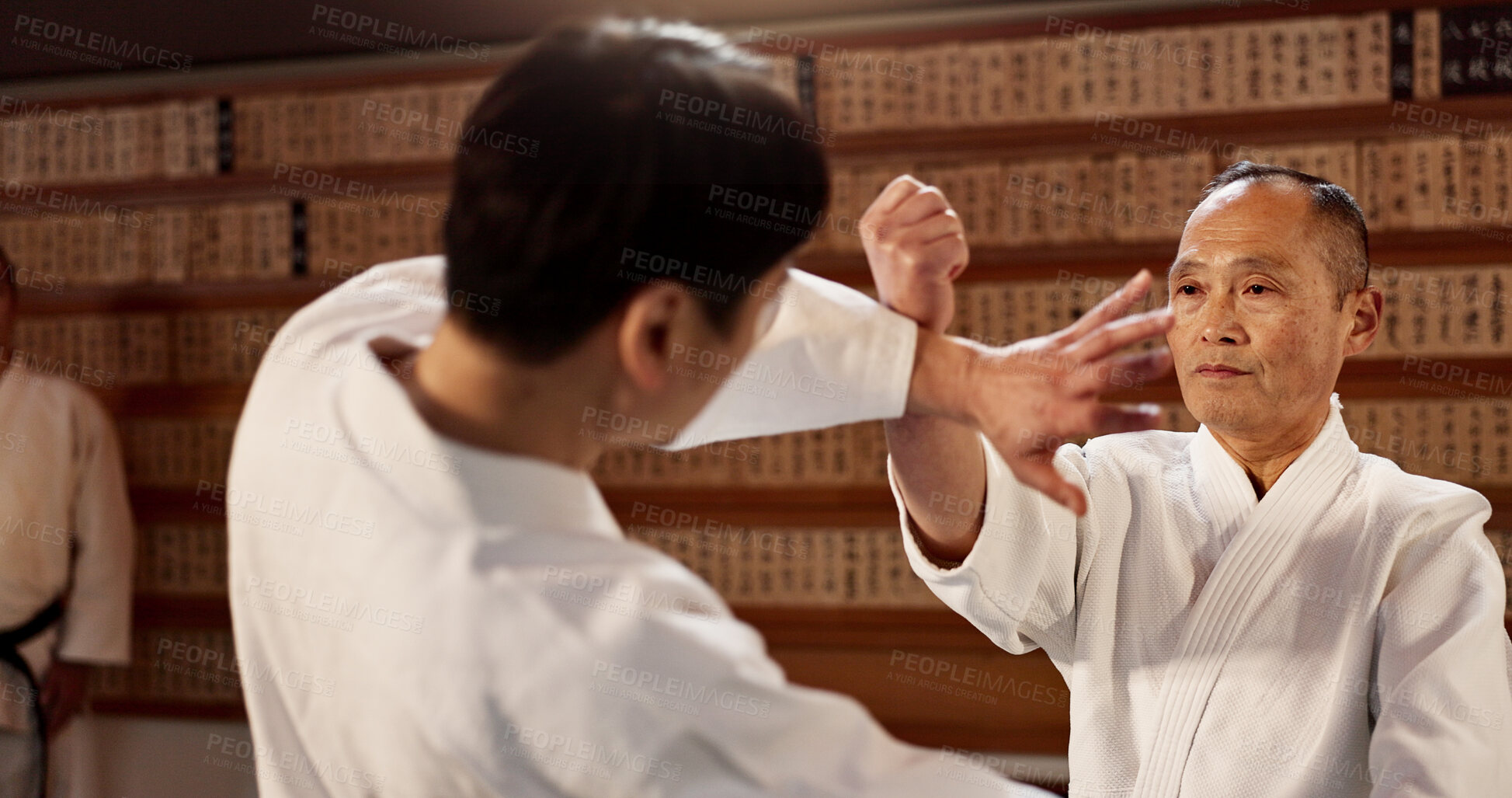 Buy stock photo Aikido class, student and sensei for martial arts, learning and advice for combat at training, gym and dojo. Japanese people, block and sports with fight, workout or fitness for zen, conflict or club