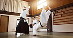 Aikido dojo with sensei, wooden sword and student training for fitness, fight and action in gym. Teaching, learning and men in traditional Japanese martial arts class with aikidoka, bokken and battle