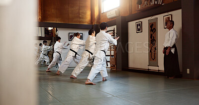 Buy stock photo Aikido, black belt and fight class with sensei training or teaching athletes for self defence exercise. Dojo, students and people in a gym or studio for workout, practice and fitness routine in Japan