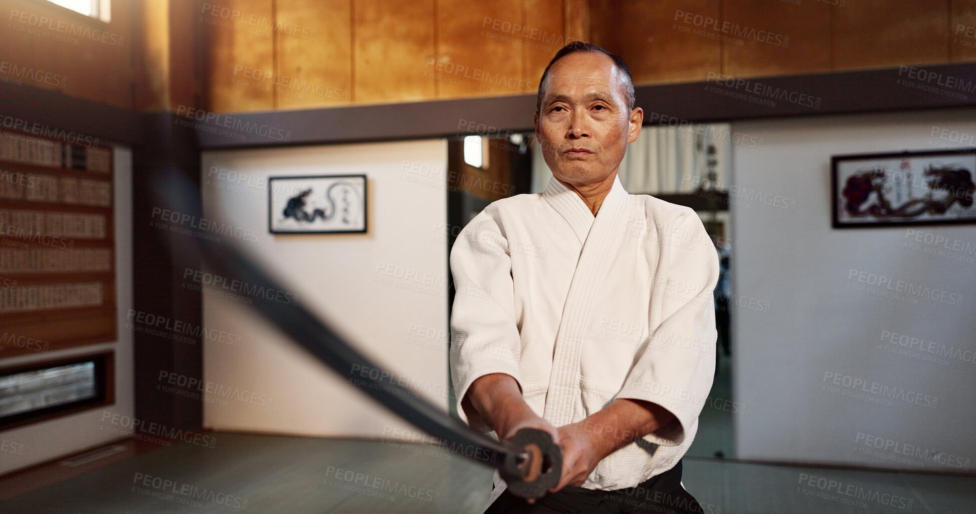 Buy stock photo Japanese master, aikido and training with sword, modern martial arts and teacher of self defence. Sensei, black belt or katana in dojo place, sport or weapon demonstration by mature fighter in combat