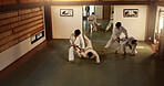 Aikido students, bow or learning martial arts in dojo for practice, body movement or self defense. Combat demonstration, Japanese people or black belt training workout for fighting education or class