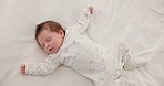 Sweet, sleeping and newborn baby on a bed at a home in the bedroom for resting and dreaming. Cute, tired and top view of infant, child or kid taking a nap in the morning in nursery at family house.